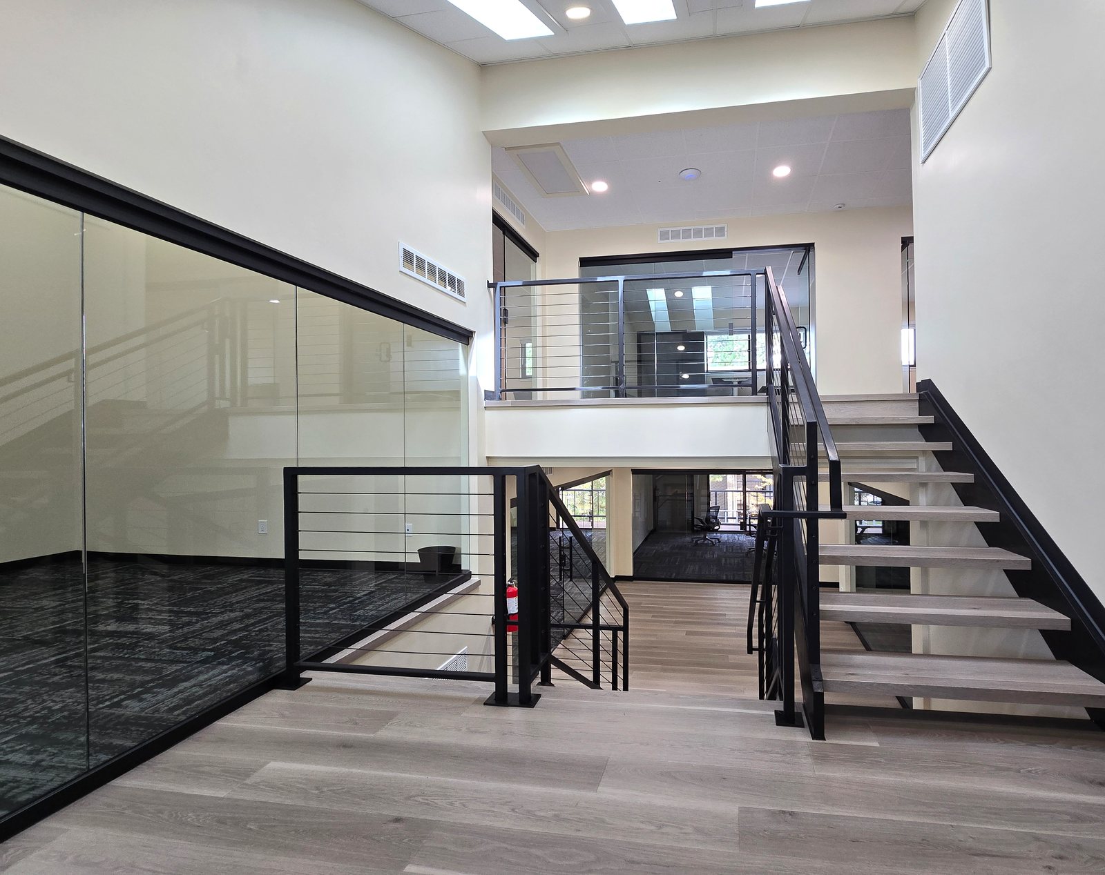 Two levels of glass offices and the central stair inside ZipDesk Coworking Building 5
